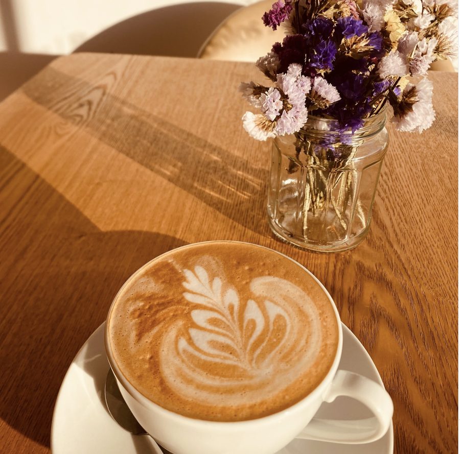 Café latte com arte em espuma e flores secas