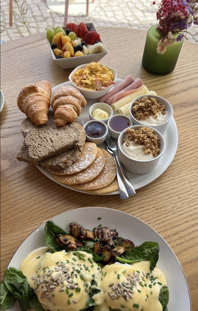 Mesa completa de brunch com fruta, croissants e panquecas